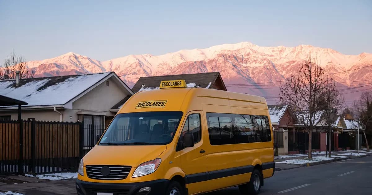 Furgón escolar amarillo en una calle de Santiago con la cordillera al atardecer